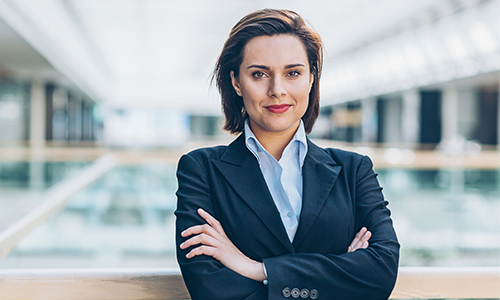 A woman attorney in library with arms crossed